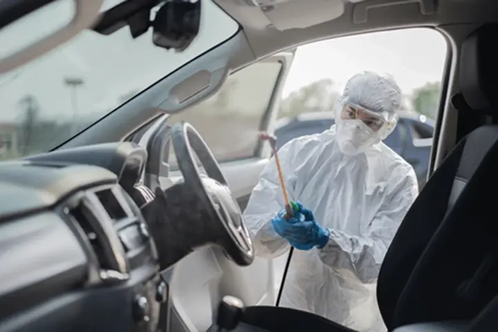 Person with a sprayer cleaning inside car